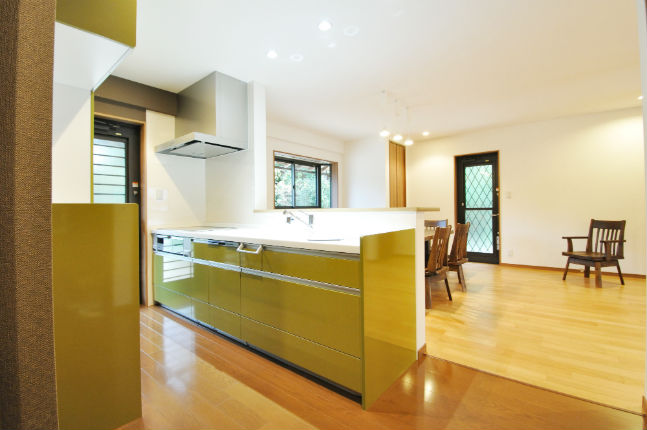 オリーブグリーンの対面キッチンとカップボードでおしゃれな空間